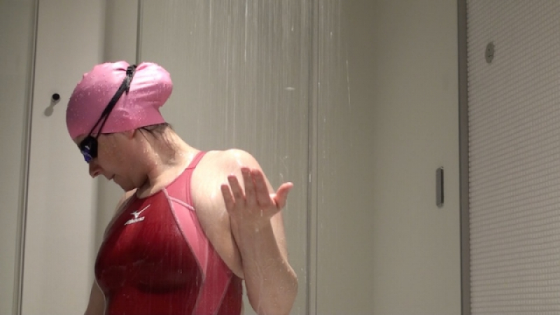 Tight wet red Mizuno swimsuit under shower